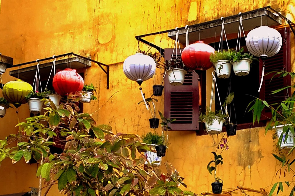 Silk lanterns on a yellow wall in Hoi An's ancient town