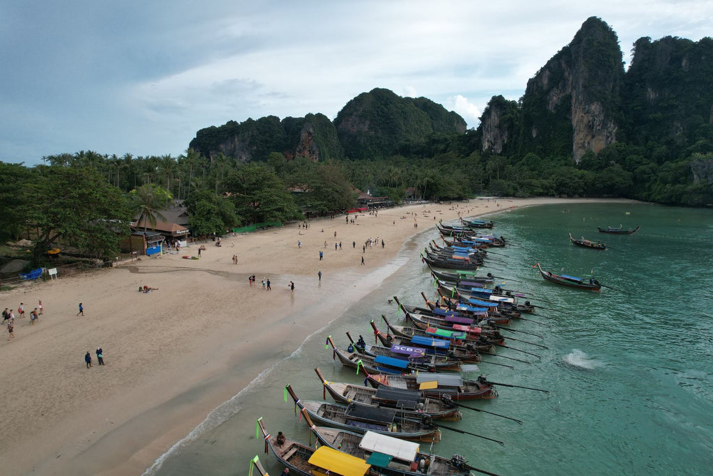 Aerial view of a beach with longtail boats and cliffs, Krabi