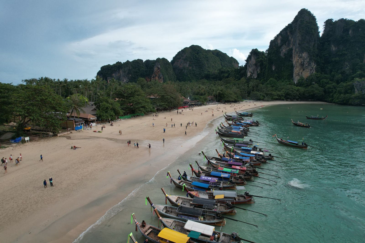 Aerial view of a beach with longtail boats and cliffs, Krabi