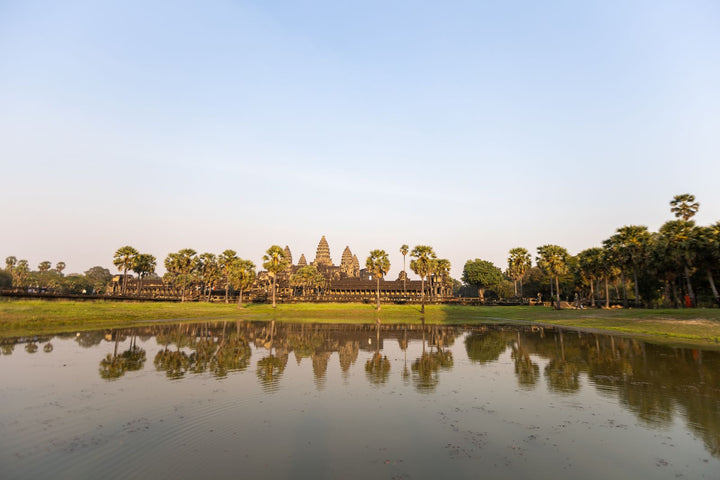 Sunrise over Angkor Wat with palm trees