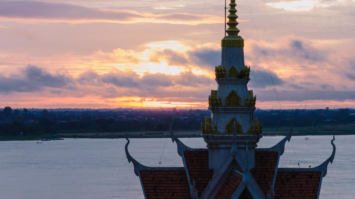 Temple silhouette in Phnom Penh at sunset over the Mekong